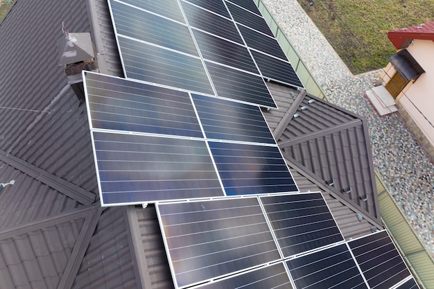 Tetto di una casa privata coperto con pannelli solari fotovoltaici per la generazione di energia elettrica ecologica pulita nell'area suburbana della città rurale Concetto di casa autonoma