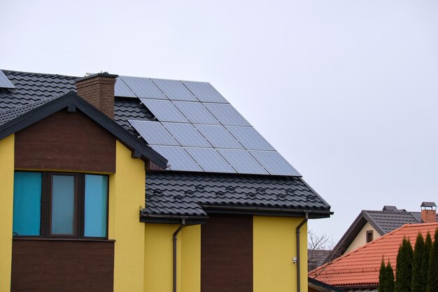 Tetto di una casa privata coperto con pannelli solari fotovoltaici per la generazione di energia elettrica ecologica pulita nell'area suburbana della città rurale Concetto di casa autonoma