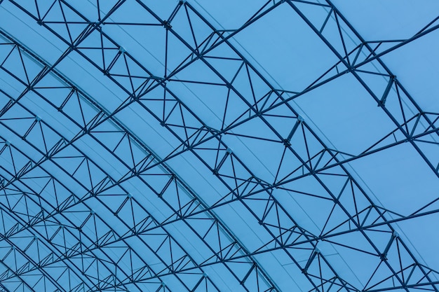 Tetto in vetro a forma di triangoli sullo sfondo del cielo azzurro. Il tetto di un edificio per uffici, un centro commerciale. Riflessione del cielo.