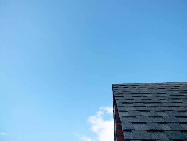 Tetto nero con sfondo azzurro, mezzogiorno e cielo azzurro con tetto