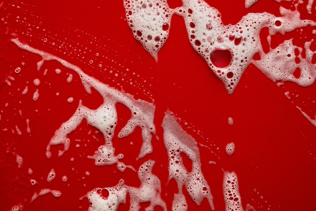Textura di schiuma di sapone bianca con bolle astratto sfondo rosso shampoo gel per doccia sapone crema per il viso mousse di pulizia campione
