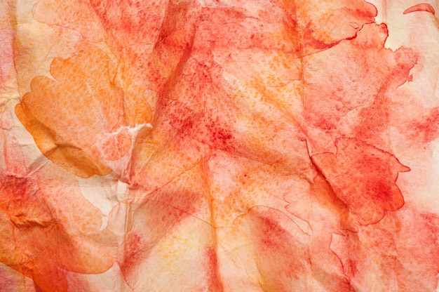 Texture da macchie di acquerello rosse e arancioni su carta stropicciata