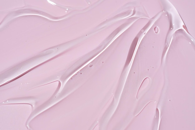 Texture del siero per il viso Sfondo astratto di gel idratante trasparente su sfondo rosa