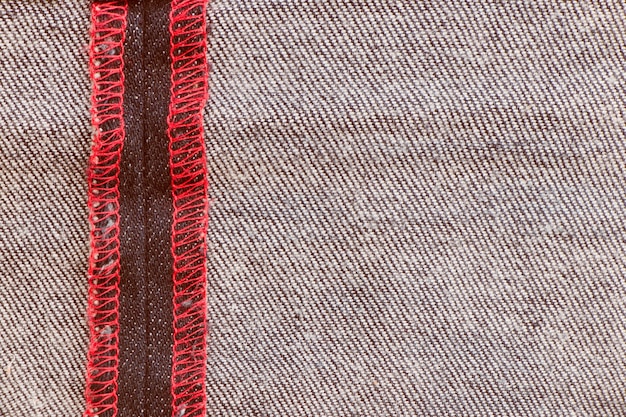 Texture denim con cucitura rossa per sfondo jeans