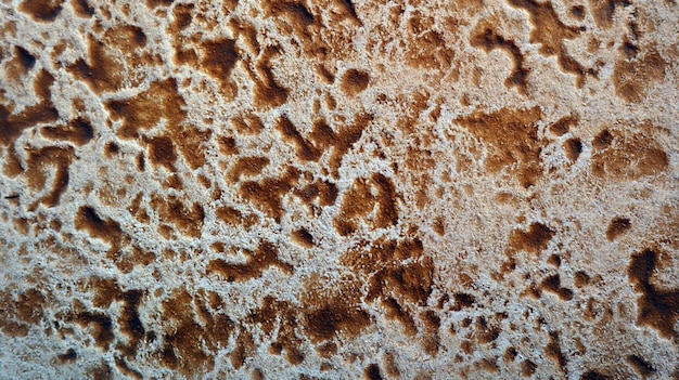 Texture di piastrelle in pietra, pietra naturale, transizioni di macchie di colore giallo marrone, sfondo naturale neutro