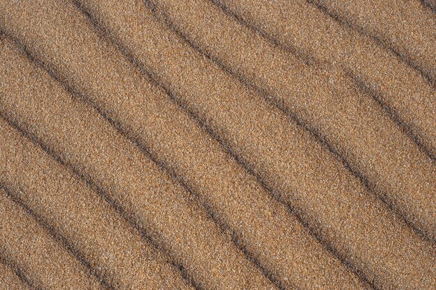 Texture di sabbia con disegno di dune di sabbia sfondo naturale