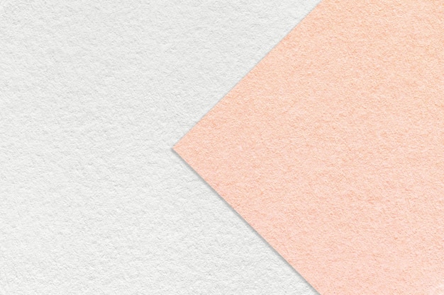 Texture di sfondo di carta bianco e rosa chiaro a metà due colori con macro freccia Struttura di cartone rosa artigianale