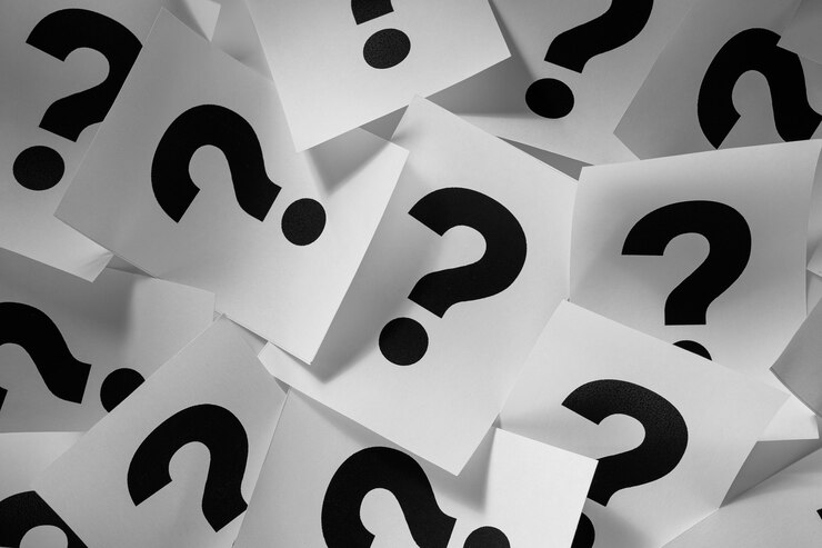 Texture di sfondo di punti interrogativi stampati su fogli di carta bianca in modo casuale sparsi