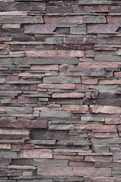 Texture di un muro di pietra da pietre lunghe e ruvide di diverse dimensioni e toni