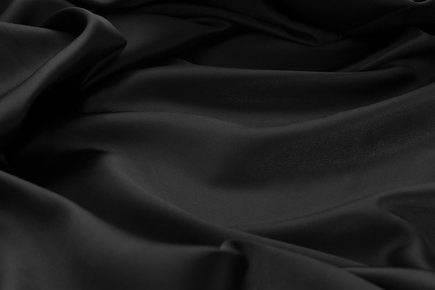 Texture La superficie del tessuto in tessuto increspato in raso nero ci ha utilizzato per la progettazione di prodotti di lusso sullo sfondo