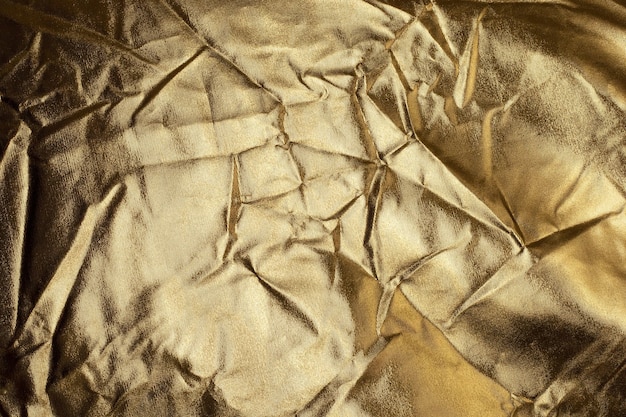 Texture lamina d'oro, lucida e piegata. Fondo astratto dell'oro.