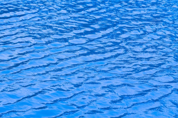 Texture onda d'acqua in piscina con riflessi soleggiati