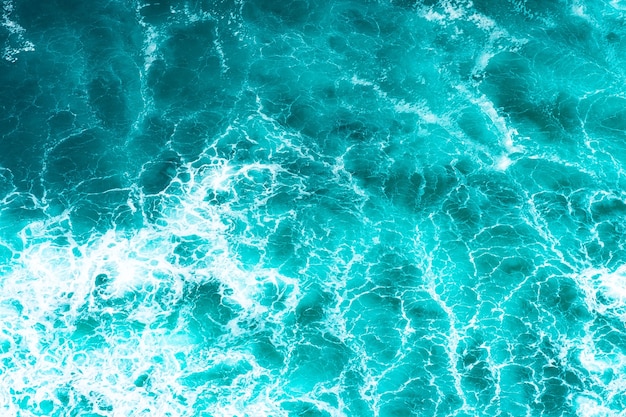 Texture Superficie azzurra dell'acqua di mare impetuosa con schiuma bianca e onda