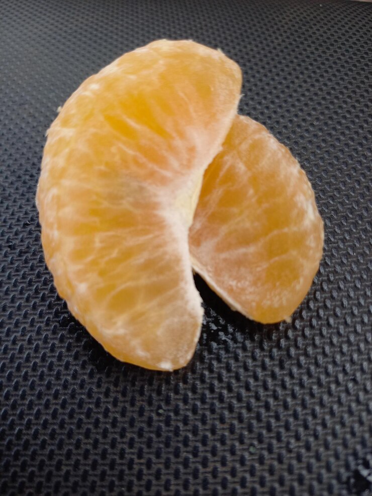 The oranges are cut in half and the one is peeled.