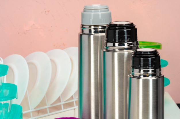 Thermos bottiglia contro stoviglie in una cucina