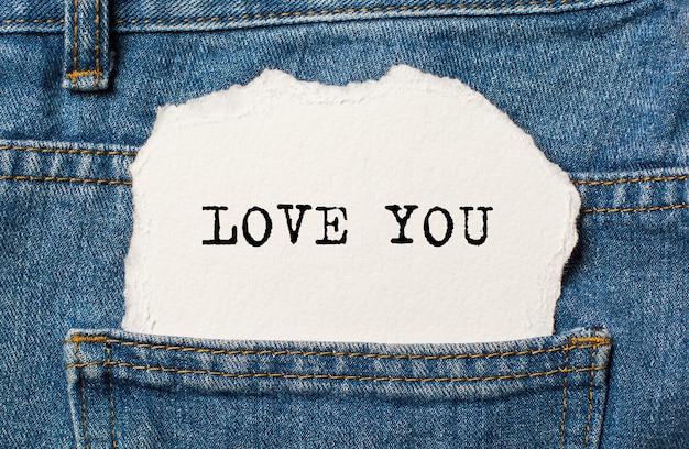 Ti amo su sfondo di carta strappata sui jeans amore e concetto di San Valentino