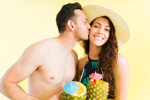 Ti amo tanto. Ragazzo adorabile che dà un bacio alla sua bella ragazza felice mentre si gode una giornata in spiaggia o in piscina