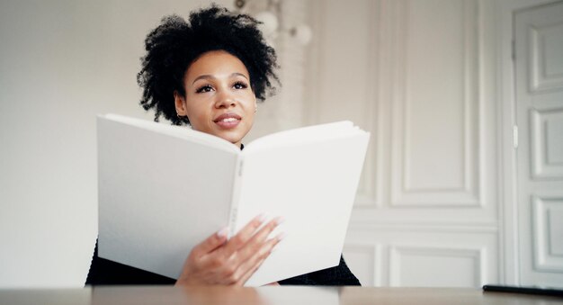 Tiene in mano un libro di testo la copertina è bianca e vuota Lo studente è intelligente