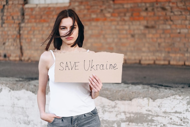 Tiene in una mano un poster Salva la guerra in Ucraina tra Russia e Ucraina
