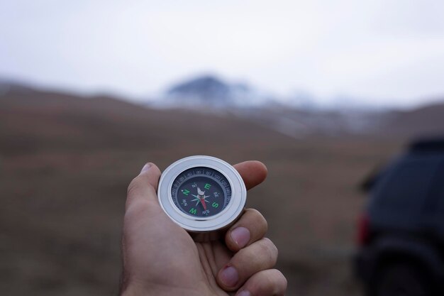 Tiene una bussola sullo sfondo di una montagna