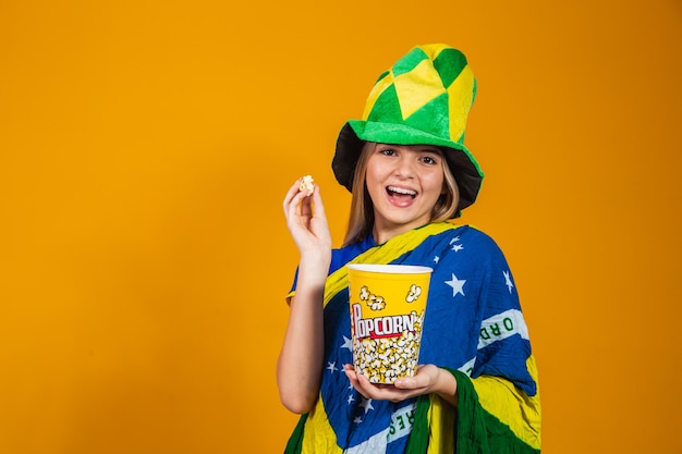 Tifoso brasiliano con popcorn per guardare la partita. concetto di intrattenimento e sport