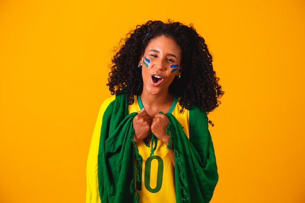 Tifoso brasiliano. indossando la bandiera brasiliana in un ritratto, fan brasiliano che celebra il calcio o la partita di calcio. I colori del Brasile.Coppa del mondo