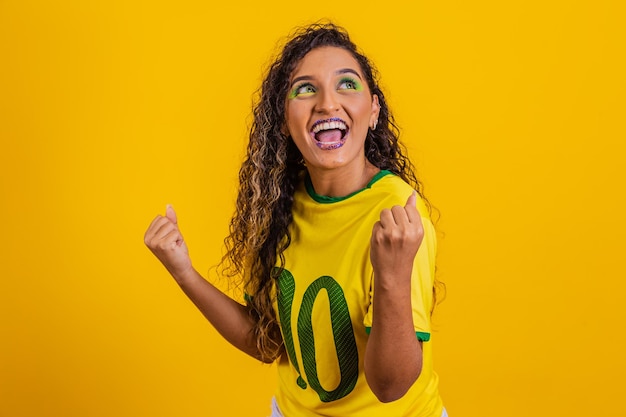 Tifoso brasiliano Tifoso brasiliano che celebra una partita di calcio o di calcio su sfondo giallo Colori del Brasile