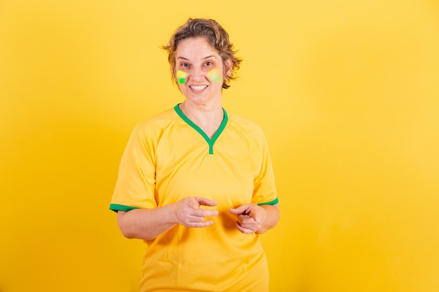 Tifoso di calcio brasiliano adulto donna adulta che punta allo schermo scegliendo te
