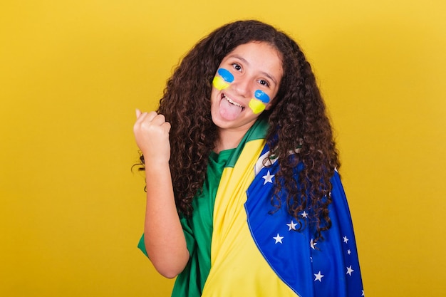 Tifoso di calcio brasiliano della ragazza caucasica che sorride urlando sì celebrando festeggiando festeggiando