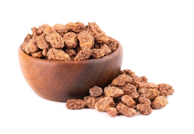 Tigernuts isolato. Noci Chufa o noci tigre nella ciotola di legno.