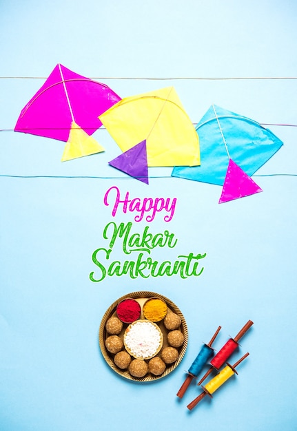 Til Gul OR Sweet Sesamo Laddu con modello in miniatura Fikri e Kite con haldi Kumkum e cristalli di zucchero per il festival Makar Sankranti su sfondo lunatico, messa a fuoco selettiva