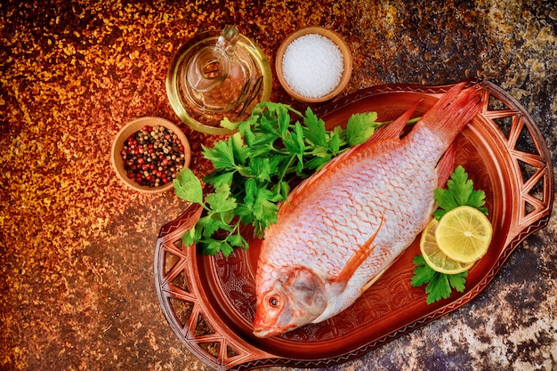 Tilapia cruda con spezie e limone. Vista dall'alto. Copia spazio.