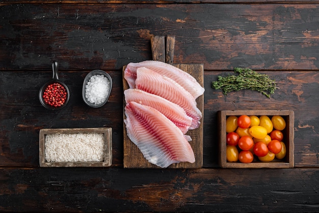 Tilapia cruda di pesce bianco, con riso basmati e ingredienti di pomodorini, su tavolo di legno scuro, vista dall'alto