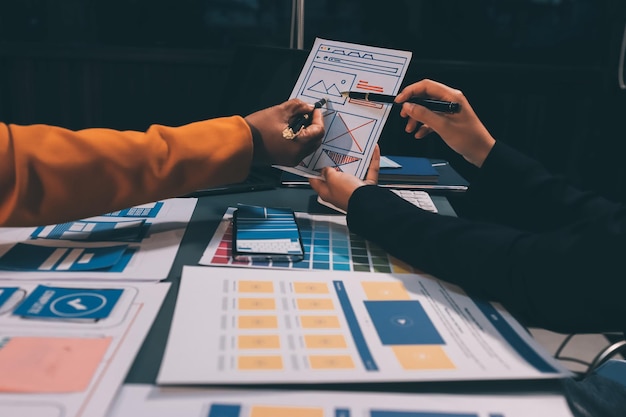 Tim designer sedang mendesain sistem uxui agar sistem uxui bekerja dengan baik di ponsel baru dan mendukung pembaruan sistem. Konsep pengembangan situs web UI UX designer bagian depan