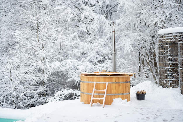 Tino caldo di legno sul terrazzo nevoso alle montagne