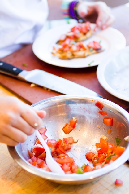 Tipi in corso di cucina che preparano le bruschette.