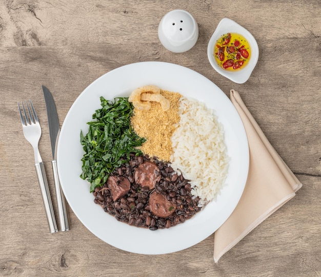 Tipica feijoada brasiliana con cavolo di farofa e pepe di riso e ciccioli