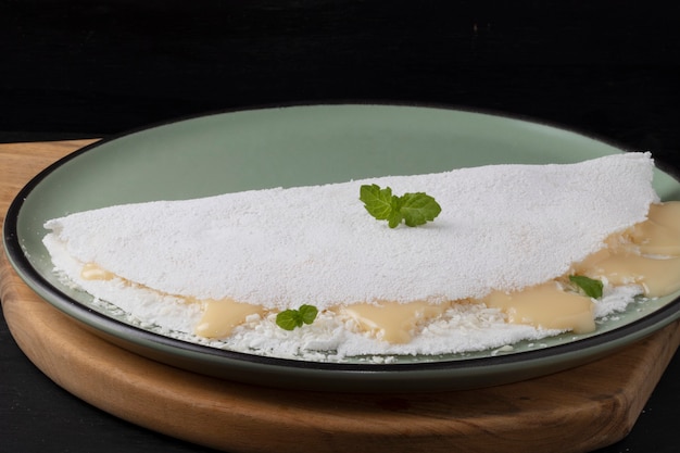 Tipica tapioca da dessert del nord-est brasiliano con latte condensato e cocco.