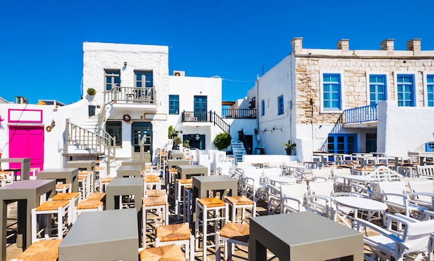 Tipica taverna greca con tavoli e sedie colorate nel porto di Naoussa