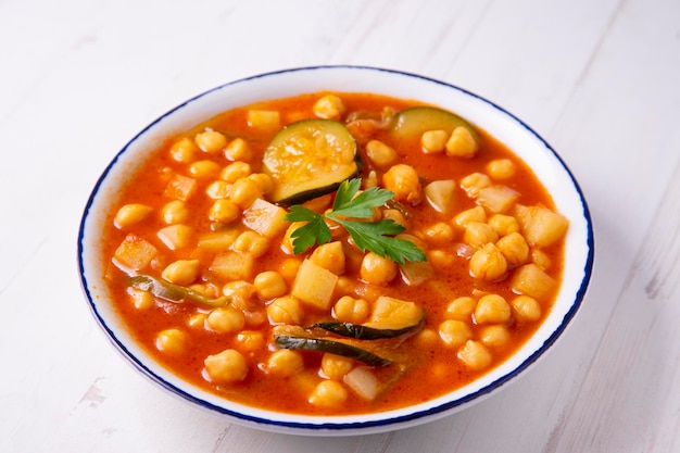 Tipico piatto spagnolo di stufato di ceci con verdure come carote, peperoni o zucchine