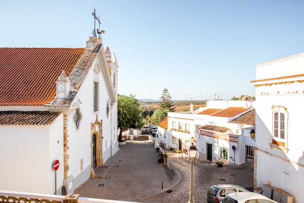 Tipico villaggio con vecchia chiesa bianca durante l'alba nel sud del Portogallo