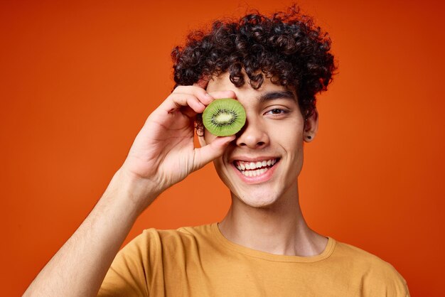Tipo riccio con kiwi nelle sue mani frutta fresca del primo piano