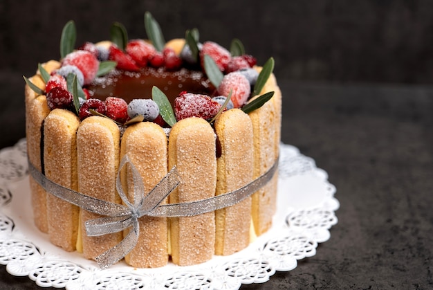 Tiramisù condito con glassa al cioccolato e decorato con frutti di bosco