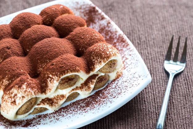 Tiramisù sul piatto sulla superficie in legno