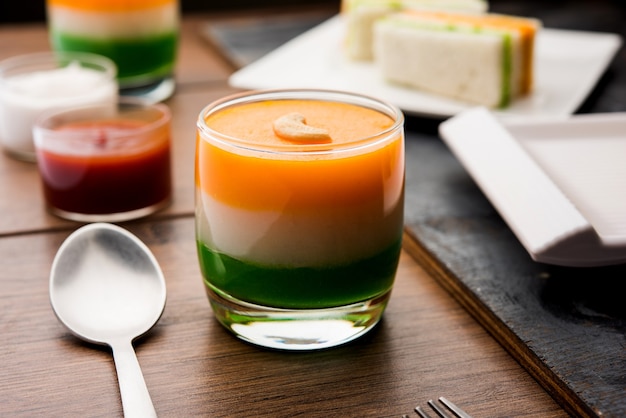Tiranga o cibo dolce tricolore realizzato con i colori della bandiera indiana e servito in un bicchiere a strati. messa a fuoco selettiva