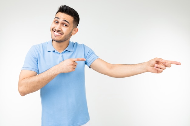 Tirante grazioso in una maglietta blu con tenersi per mano su uno studio bianco