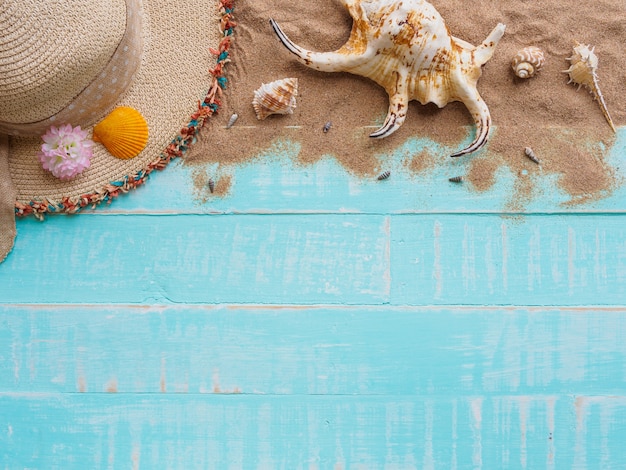 Tiri gli accessori in secco su fondo di legno pastello blu luminoso per la vacanza estiva e la vacanza