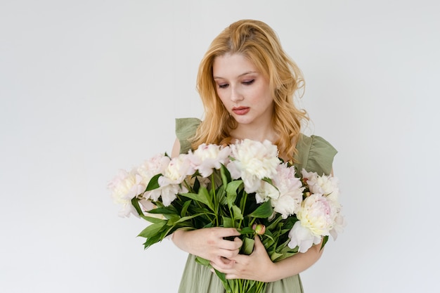 Tiro al coperto di bella ragazza con peonie bianche e rosa