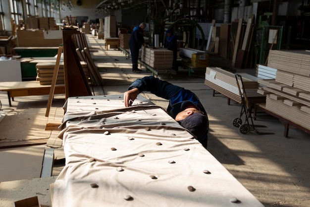 tLavoratore in un'officina di produzione di mobili Le mani realizzano un massetto per divani