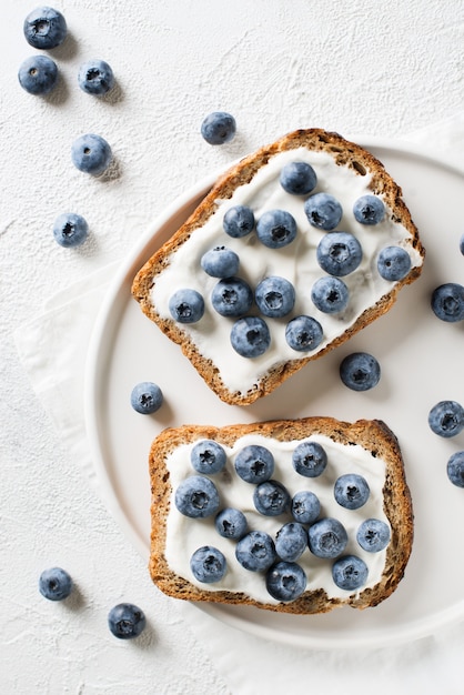 Toast ai mirtilli a colazione su sfondo bianco. Cibo salutare